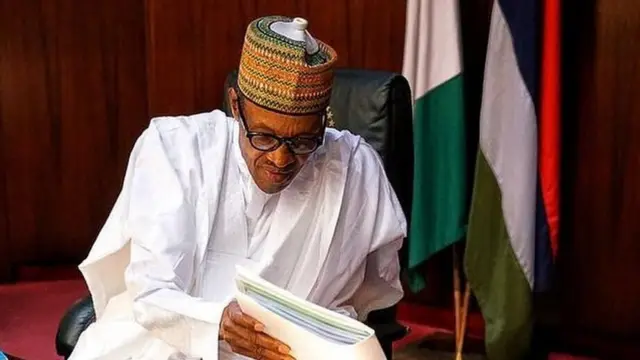 Nigeria President Muhammadu Buhari dey hold book