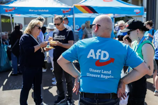 Ulrich Siegmund (a képen nem látható), a szélsőjobboldali Alternatíva Németországért (AfD) párt miniszterelnök-jelöltjének támogatói részt vesznek az AfD május elsejei családi rendezvényén 2026. május 1-jén a németországi Schönebeckben.