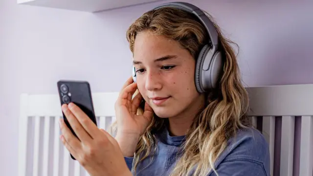 Uma adolescente olhando para um smartphone