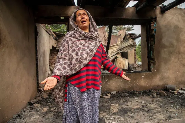 नियंत्रण रेषेजवळील उरीमधील सलामाबादमध्ये, तोफगोळ्यानं उदध्वस्त झालेल्या स्वत:च्या घरात उभी असलेली काश्मीरी महिला
