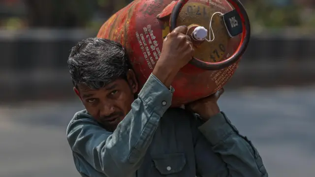 रसोई गैस सिलेंडर ले जाता व्यक्ति
