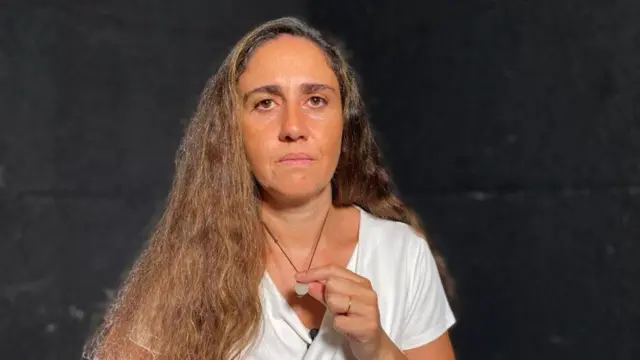 Tracey Najjar holding her pendant