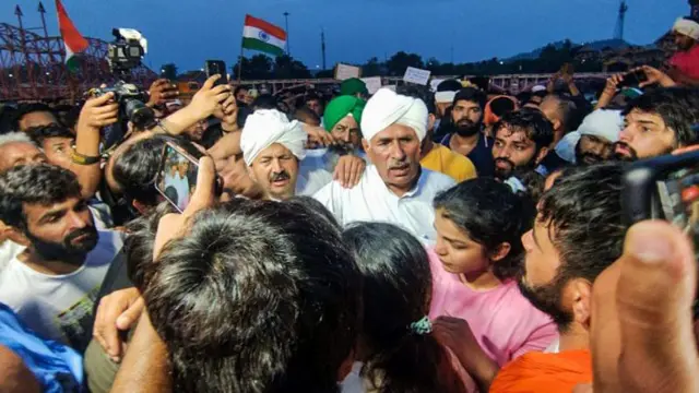 কুস্তিগিরদের গঙ্গায় মেডেল বিসর্জন না দিতে বোঝাচ্ছেন কৃষক নেতারা (মাথায় সাদা পাগড়ি) 