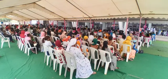 Des femmes patientent sous une salle d'attente aménagée au stade Leopold Sédar Senghor à Dakar. 