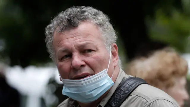 Пожилой мужчина в санитарной маске на подбородке