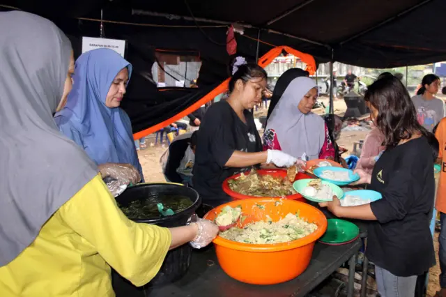 Petugas membagikan makanan kepada warga yang terdampak banjir bandang di Desa Aek Garoga, Kecamatan Batang Toru, Tapanuli Selatan, Sumatera Utara, Senin (1/12/2025). PT Agincourt Resources membuka dapur umum dengan meyediakan makanan untuk korban banjir bandang Tapanuli Selatan.
