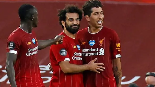 Sadio Mane, Mohamed Salah and Roberto Firmino embrace after a goal