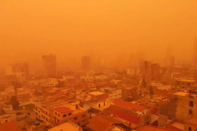 The port city of Oran covered in orange haze from a sandstorm.