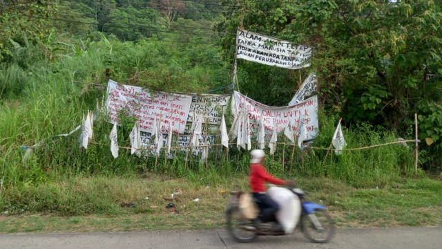 Bekas bukaan lahan kini diliputi ilalang dan blokade warga yang dipasangi spanduk penolakan warga terhadap proyek geothermal di Padarincang.