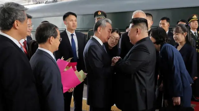 picture released by the Korean Central News Agency on September 2, 2025, shows North Korean leader Kim Jong Un walking (top), and being greeted next to his daughter Kim Ju Ae by Director of the General Office of the Chinese Communist Party (CCP) Cai Qi (bottom left) and Chinese Foreign Minister Wang Yi (bottom right), after his arrival in Beijing, China.