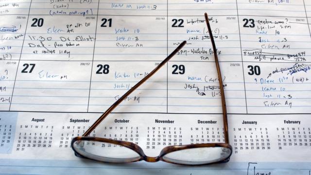 Óculos sobre calendário cheio de anotações