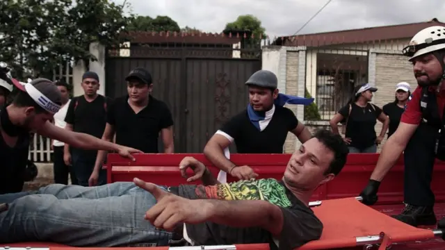 Un herido durante la marcha es evacuado en una camilla.