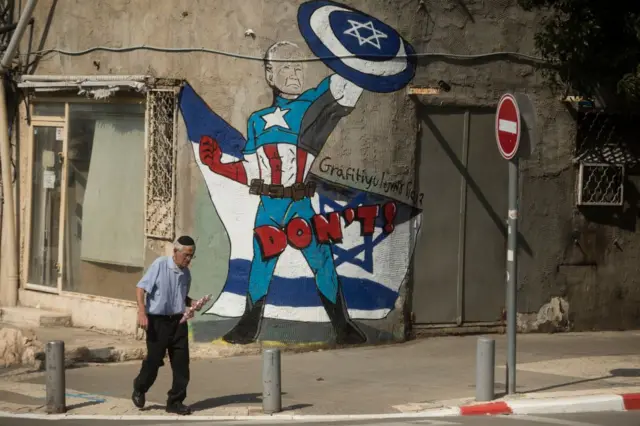 इसराइल की एक दीवार पर बनी अमेरिकी राष्ट्रपति जो बाइडेन की तस्वीर.