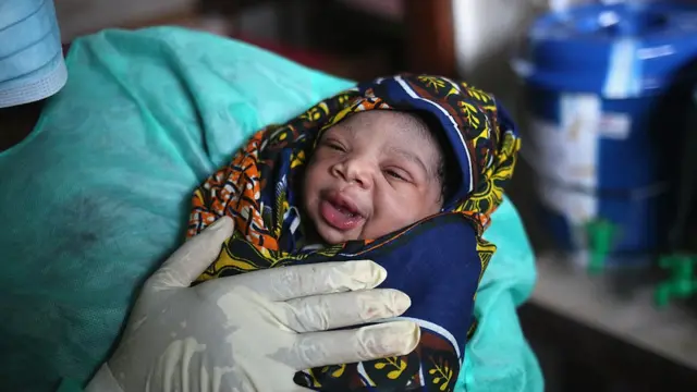 Une sage-femme tenant un bébé
