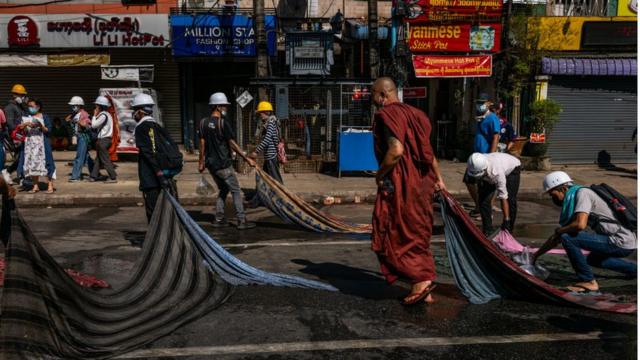 Một nhà sư giúp người biểu tình dọn dẹp đường phố ở Yangon hôm 1/3/2021