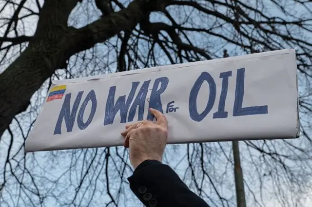 Tangan seorang pria memegang plakat bertuliskan "Tidak Ada Perang untuk Minyak" di depan AS. Kedutaan di Dublin. Demonstrasi, yang diselenggarakan oleh kelompok aktivis lokal yang dipimpin oleh Aksi Anti Imperialis (AIA), sebagian besar terdiri dari aktivis Irlandia yang kritis terhadap kebijakan luar negeri AS dan penghapusan Presiden Nicolás Maduro pada Minggu (4/1) di Dublin, Irlandia