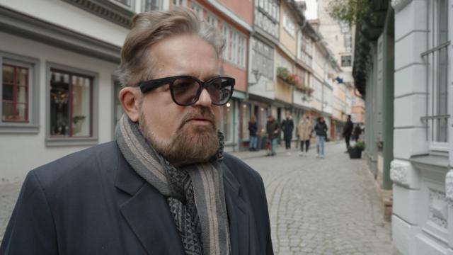 Мужчина в очках на улице немецкого города