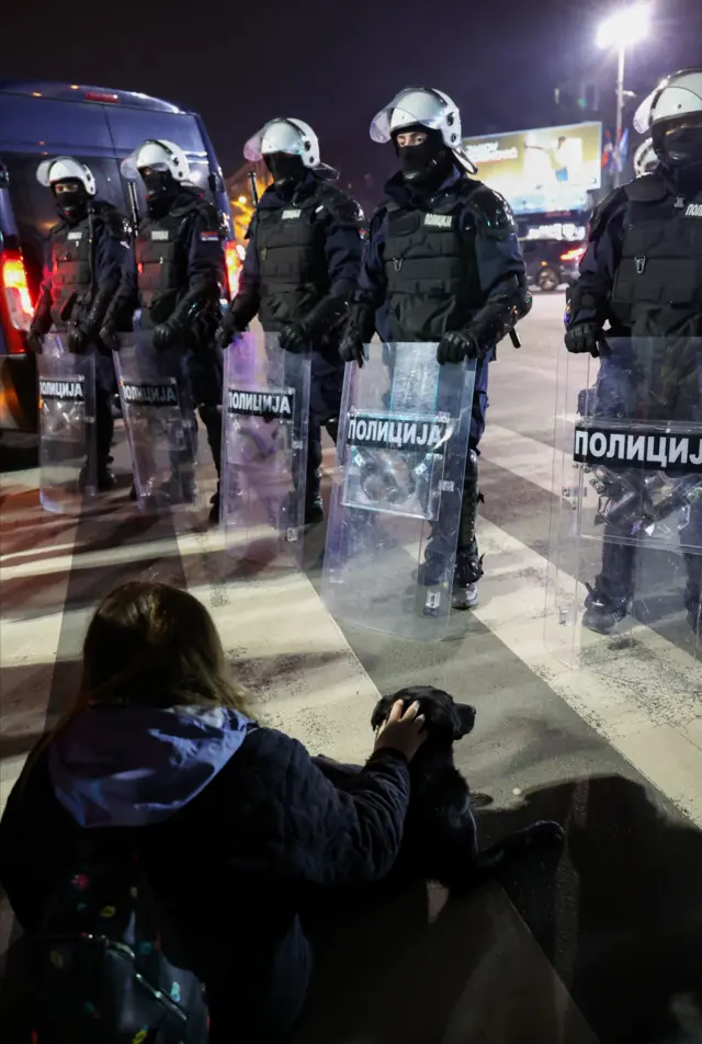 protest u Novom Sadu i incidenti, devojka sa psom sedi ispred policijskog kordona u novom sadu
