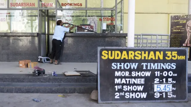 An Indian worker cleans a booking counter at a cinema theatre in Hyderabad on March 2, 2018.