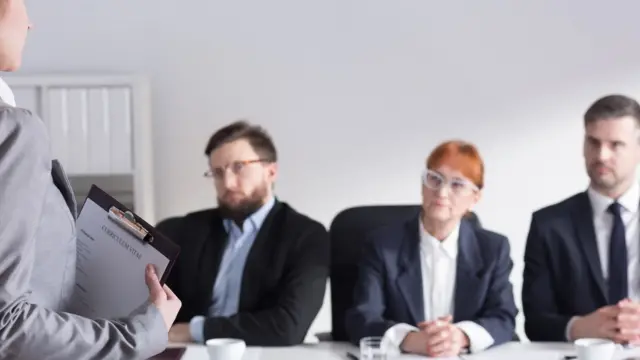 Una joven que se enfrenta a un panel de entrevistadores