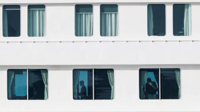 Las ventanas del crucero muestran a sus tripulantes antes de la evacuación.
