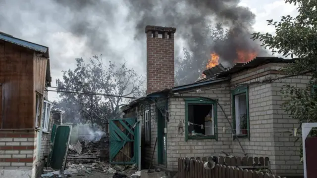 দোনেৎস্কের ভের্কনোকামিয়নস্কে গোলার আঘাতের পর একটি বাড়িতে আগুন জ্বলছে