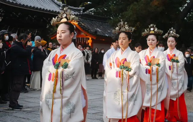 In Osaka, Japan, four young women dressed in traditional kimono take part in a Shinto ritual procession to mark the end of the year at Sumiyoshi Taisha, one of Japan's oldest Shinto shrines.