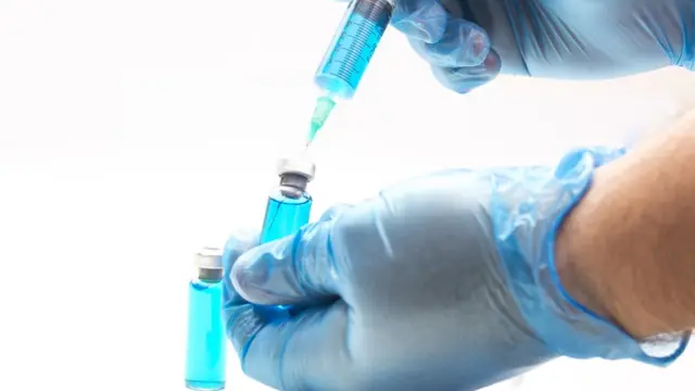 Persona preparando una dosis de vacuna.