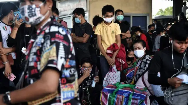 Người di dân Myanmar, Lào và Cambodia chen nhau đợị xe buýt rời khỏi Bangkok Thái Lan để về nhà khi bệnh dịch lây lan nhanh ở nước này