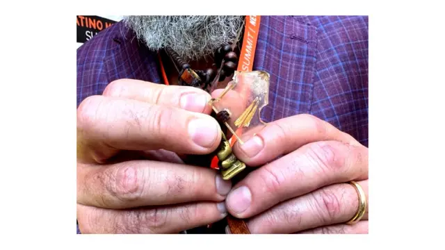 Manuel Oliver nos enseña durante la entrevista un pedacito de acrílico que contiene una porción de las flores que Joaquín le regaló a su novia el día que fue asesinado. Hace parte de su collar.