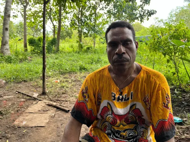 Seorang pria Papua sedang menggunakan kaos Bali.