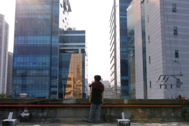 Hyuk standing on the rooftop of the building