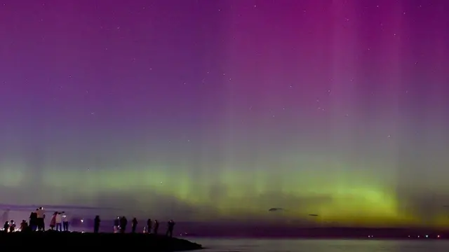 Foto colorida mostra céu estrelado com 'ondascassino pagando no cadastro sem depósitoluz' verdes, roxas e azuis sobre o mar