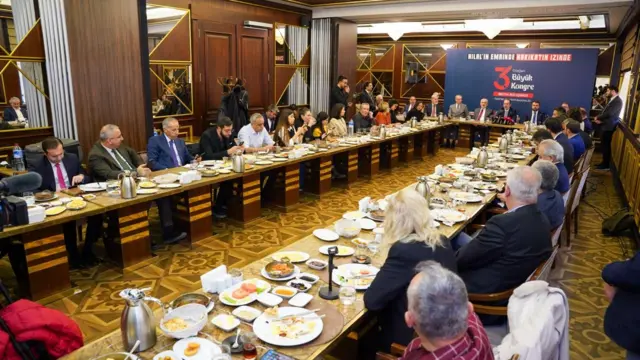 YRP lideri Fatih Erbakan'ın medya buluşmasının geniş fotoğrafından çok sayıda gazeteci masada oturuyor