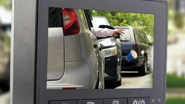 La imagen muestra una cámara de tablero que captura imágenes de un hombre dejando caer un vaso de cartón por la ventana de su automóvil.