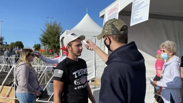 Un joven se toma la temperatura en Mosinee antes de un rally de Trump.