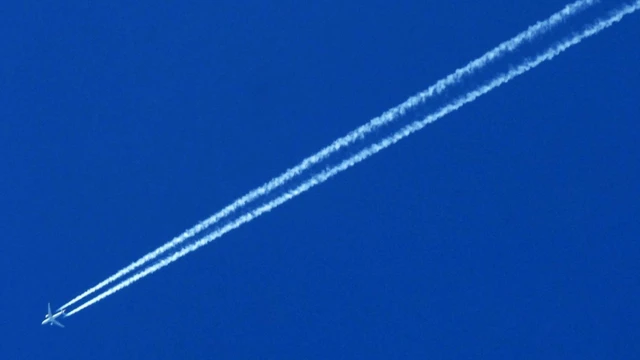 An airplane trailed by a contrail