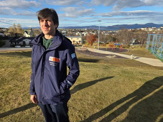 Hombre en un parque con la ciudad de Ushuaia de fondo