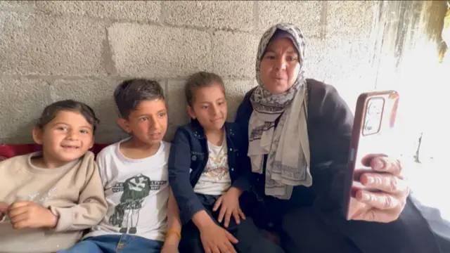 አያት እና የልጅ ልጆች በስልክ እያወሩ 