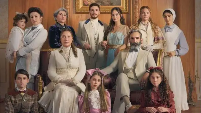 Tarihi kıyafetlerle yan yana poz veren bir aile