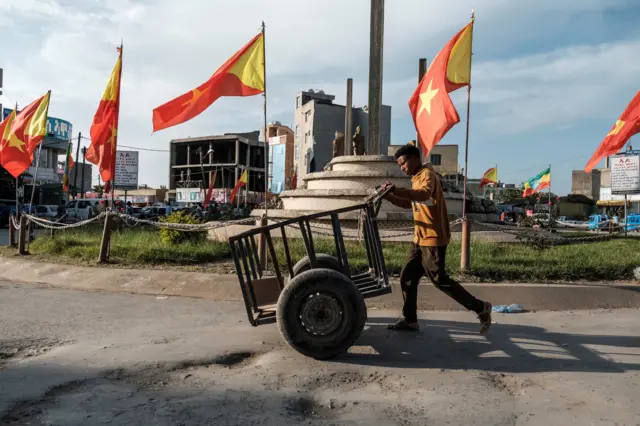 የትግራይ ባንዲራ በተሰቀለበት አደባባይ በኩል የሚያልፍ ወጣት