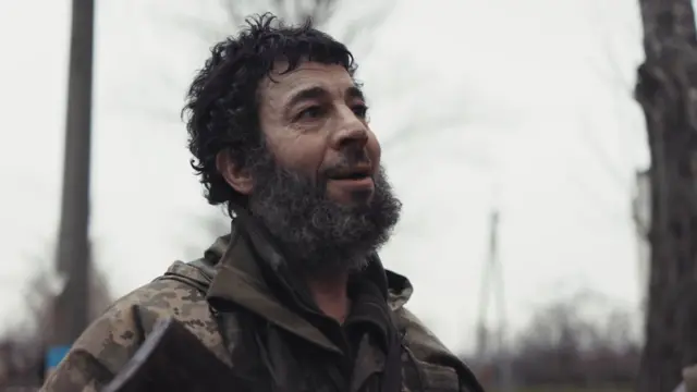 Фото крупним планом українського військового з темним волоссям і бородою