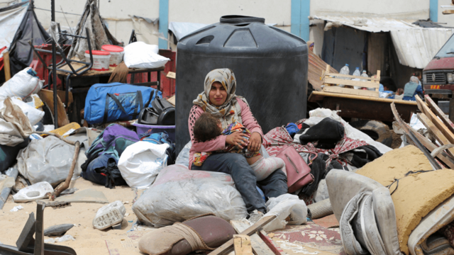 Una mujer abraza a su bebé en medio de la destrucción causada por el ataque de Israel.