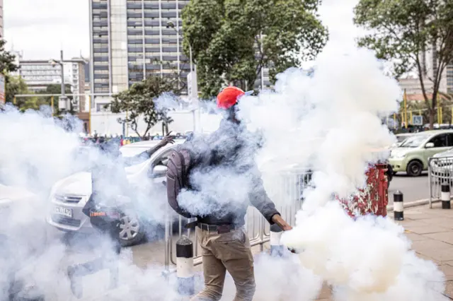 A man holds a tear gas canister thrown by Kenyan police officers during a protest against police brutality and harassment, especially against the poor, in Nairobi on July 7, 2021.