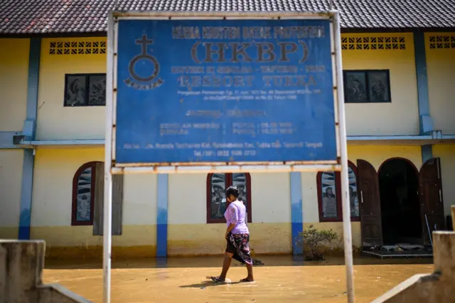 Warga korban banjir bandang dan longsor berjalan di kawasan Gereja HKBP Ressort Tuka, Hutanabolon, Kecamatan Tukka,Tapanuli Tengah, Sumatera Utara, Selasa (23/12/2025).