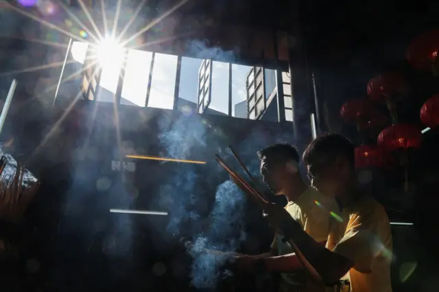 मलेशियाको क्वालालम्पुरस्थित ताओपन्थको सिन स्जे सी या मन्दिरमा प्रार्थना गर्दै मानिसहरू।