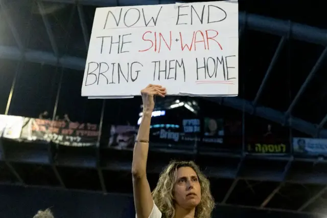 Manifestante israelí con una pancarta pidiendo el fin de la guerra y la liberación de los rehenes.