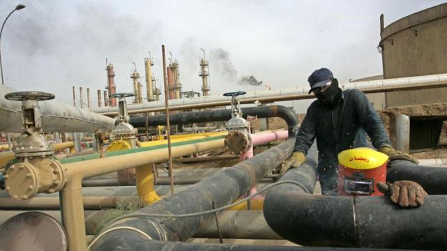 یک کارگر عراقی در ۱۴ آبان ۱۳۸۸ در بغداد، انتشار گاز از یک لوله نفت را در پالایشگاه نفت دائورا اندازه‌گیری می‌کند