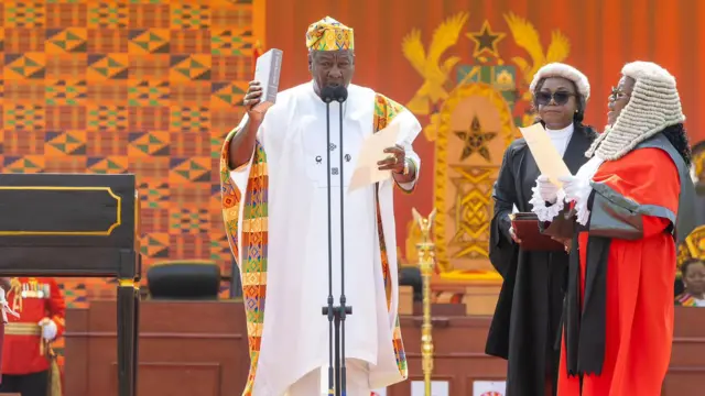 John Mahama raising bible during oath taking