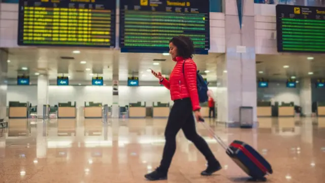 Una mujer pasea en un aeropuerto.